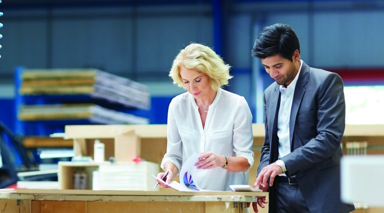 Man and woman looking at paperwork in a warehouse